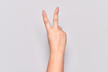 Hand of caucasian young woman counting number 2 showing two fingers, gesturing victory and winner symbol