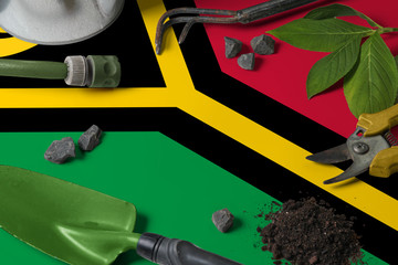Vanuatu flag with gardening tools background on table. Spring in the garden concept with free copy...