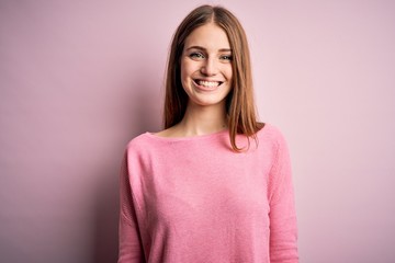 Fototapeta premium Young beautiful redhead woman wearing casual sweater over isolated blue background with a happy and cool smile on face. Lucky person.