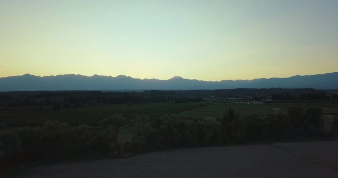 Ascending aerial flight with backtracking view to reveal Mountain Range of Cordillera de los Andes during golden hour

