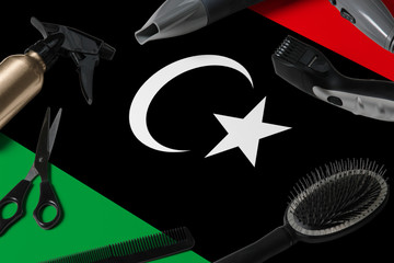 Libya flag with hair cutting tools. Combs, scissors and hairdressing tools in a beauty salon desktop on a national wooden background.