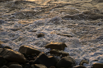 Espuma del mar de mazatlan chocando con las rocas y la arena