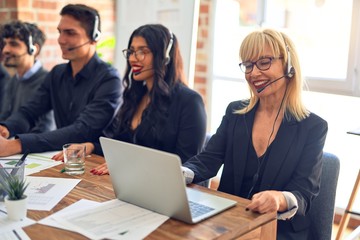 Group of call center workers smiling happy and confident. Working together with smile on face using headset at the office.