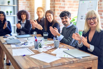 Group of business workers smiling happy and confident. Working together with smile on face looking at the camera applauding at the office