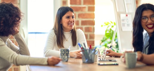 Group of businesswomen smiling happy and confident. Sitting relaxed with smile on face. Speaking taking rest at the office