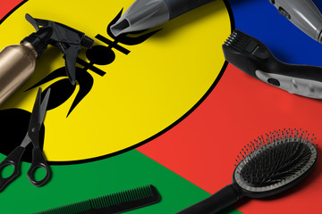 New Caledonia flag with hair cutting tools. Combs, scissors and hairdressing tools in a beauty salon desktop on a national wooden background.