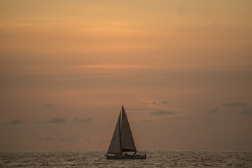 Fototapeta premium Atardecer en el mar de Mazatlan cielo despejado con velero o barco y barco de vela