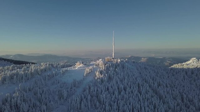 Communication Tower and Ski Tracks in Uludag, Turkey. Cinematic Aerial View of Peaks Under Evening Sun