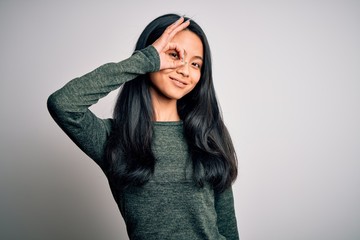 Young beautiful chinese woman wearing casual t-shirt over isolated white background doing ok gesture with hand smiling, eye looking through fingers with happy face.