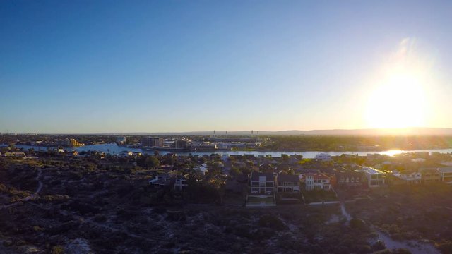 Early morning aerial view of South Australian beach with sun rising over Adelaide Hills and West Lakes, and Tennyson homes overlooking the sea.