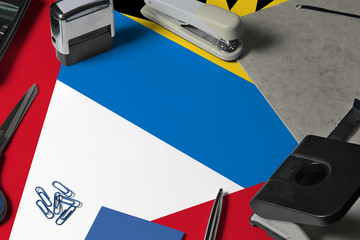 Antigua and Barbuda flag with office clerk workplace background. National stationary concept with office tools.