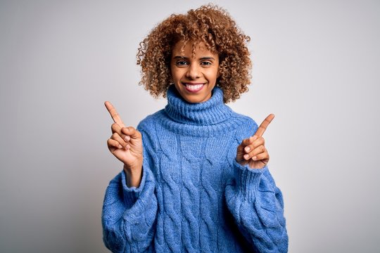 Young beautiful african american woman wearing turtleneck sweater over white background smiling confident pointing with fingers to different directions. Copy space for advertisement