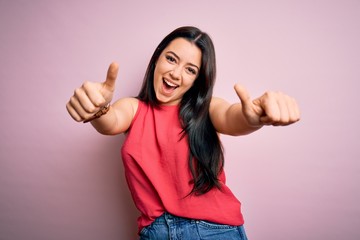 Young brunette woman wearing casual summer shirt over pink isolated background approving doing...