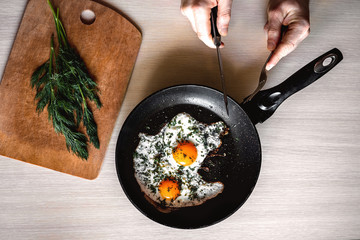 man eating breakfast straight from the pan. freshly made scrambled eggs
