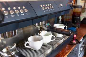 two black coffee in white cup on coffee maker machine