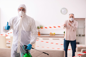 Young male sanitizer and old man indoors