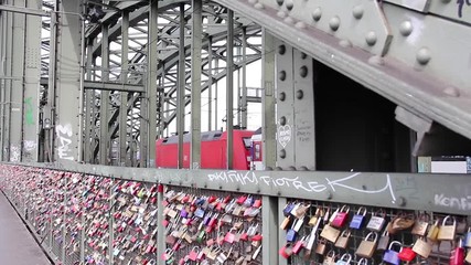 Shot of the "love locks" padlocks on the Hohenzollernbrüke bridge in Cologne Germany with a train passing in the background on the rail bridge - Powered by Adobe