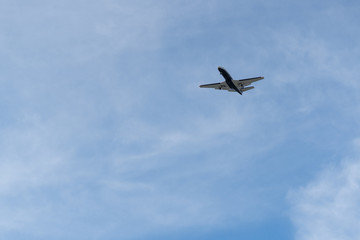 Fototapeta na wymiar Airplane on a cloudy sky background on a sunny day.
