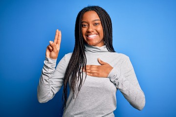 Young african american woman standing wearing casual turtleneck over blue isolated background...