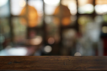 Empty dark wooden table in front of abstract blurred bokeh background of restaurant . can be used for display or montage your products.Mock up for space.