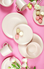 Top view of modern pastel pink, ceramic tableware on pink nackground. Creative concept cooking, kitchen flatlay layout. Vertical.