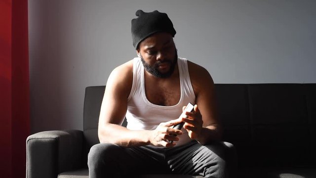 Black man at home using his phone and card to order food online during quarantine time