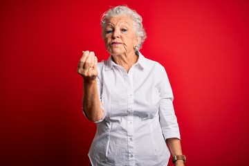 Senior beautiful woman wearing elegant shirt standing over isolated red background Doing Italian gesture with hand and fingers confident expression