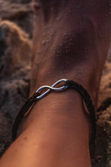 Female foot on the beach. Female anklet