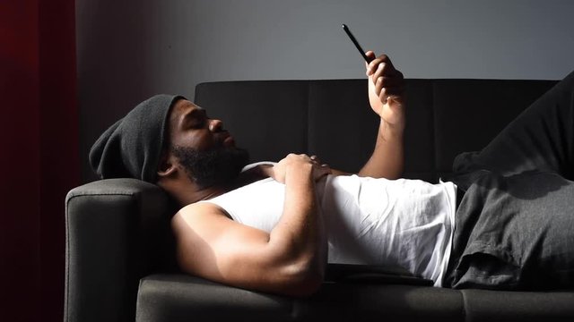 Black man at home using his phone and card to order food online during quarantine time