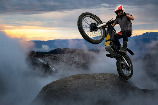 Extreme Adventure Man Motorcycle Trials On Top Of A Rock. Dramatic Mountain Sunset Composite. Landscape From British Columbia, Canada.