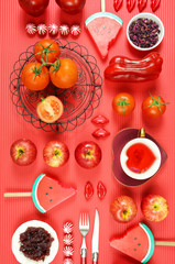 Red foods including apples, tomatoes, cranberry, watermelon, and red rose tea, with powerful healthy antioxidants, lycopene, anthocyanins, vitamin C. Creative concept flatlay. Vertical.