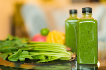 Two bottles of healthy green smoothie mixed with fruits and vegetables