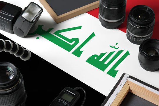 Iraq national flag with top view of personal photographer equipment and tools on white wooden table, copy space. - Powered by Adobe