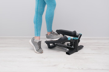 Woman exercising on a twister  stepper. Digital display, keeping fit at home.  Home cardio workout.