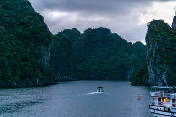 Fototapeta na wymiar Sunset view of limestone pillars and fisherman boat at Halong, Ha Long Bay, Vietnam