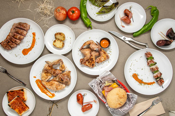Still life with plates of grilled food