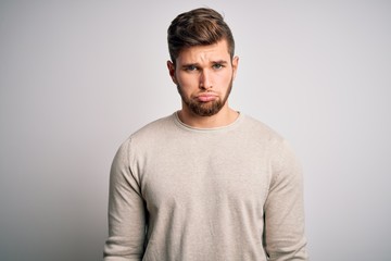 Obraz premium Young handsome blond man with beard and blue eyes wearing casual sweater depressed and worry for distress, crying angry and afraid. Sad expression.