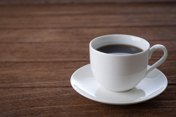 Black coffee in a white mug on the desk