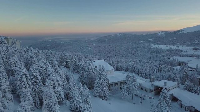 Uludag Mountain, Bursa Province, Turkey. Pull Back Aerial of Winter Landscape and Snow Capped Forest In Twilight