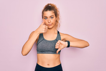 Fototapeta na wymiar Young beautiful blonde sportswoman with blue eyes doing exercise wearing sportswear Doing thumbs up and down, disagreement and agreement expression. Crazy conflict