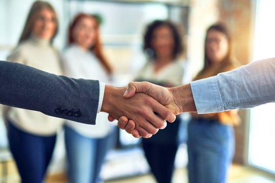 Group of business workers standing together shaking hands at the office