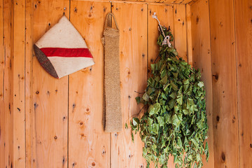 Felt sauna hat,birch broom and eco washcloth on wooden background.Bath accessories.