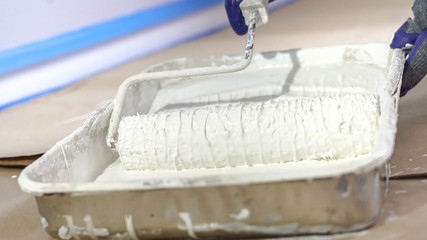 Close Up Shot of White Paint being applied on a Roller.
