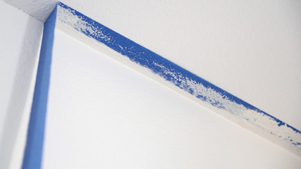 Removing masking blue tape from ceiling.