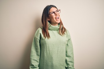 Young beautiful woman wearing casual sweater standing over isolated white background looking away to side with smile on face, natural expression. Laughing confident.