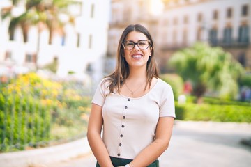 Young beautiful woman smiling happy and confident. Standing with smile on face at the town street