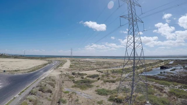 Drone footage of remote industrial area near power station and high-voltage towers, taken at Outer Harbor, Port Adelaide, South Australia. Panning up.