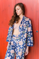 Fototapeta premium Young attractive woman dressed in beautiful colorful pajama posing as a model in her bedroom. Comfortable sleepwear, home relaxation and female fashion concept.