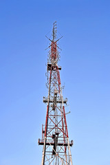 radio, television and mobile antenna tower with jammer aka muffler function on blue sky, telecommenications diversity