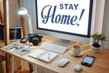 Workspace of wedding photographer with computer, planner and printed photos working from home during pandemic